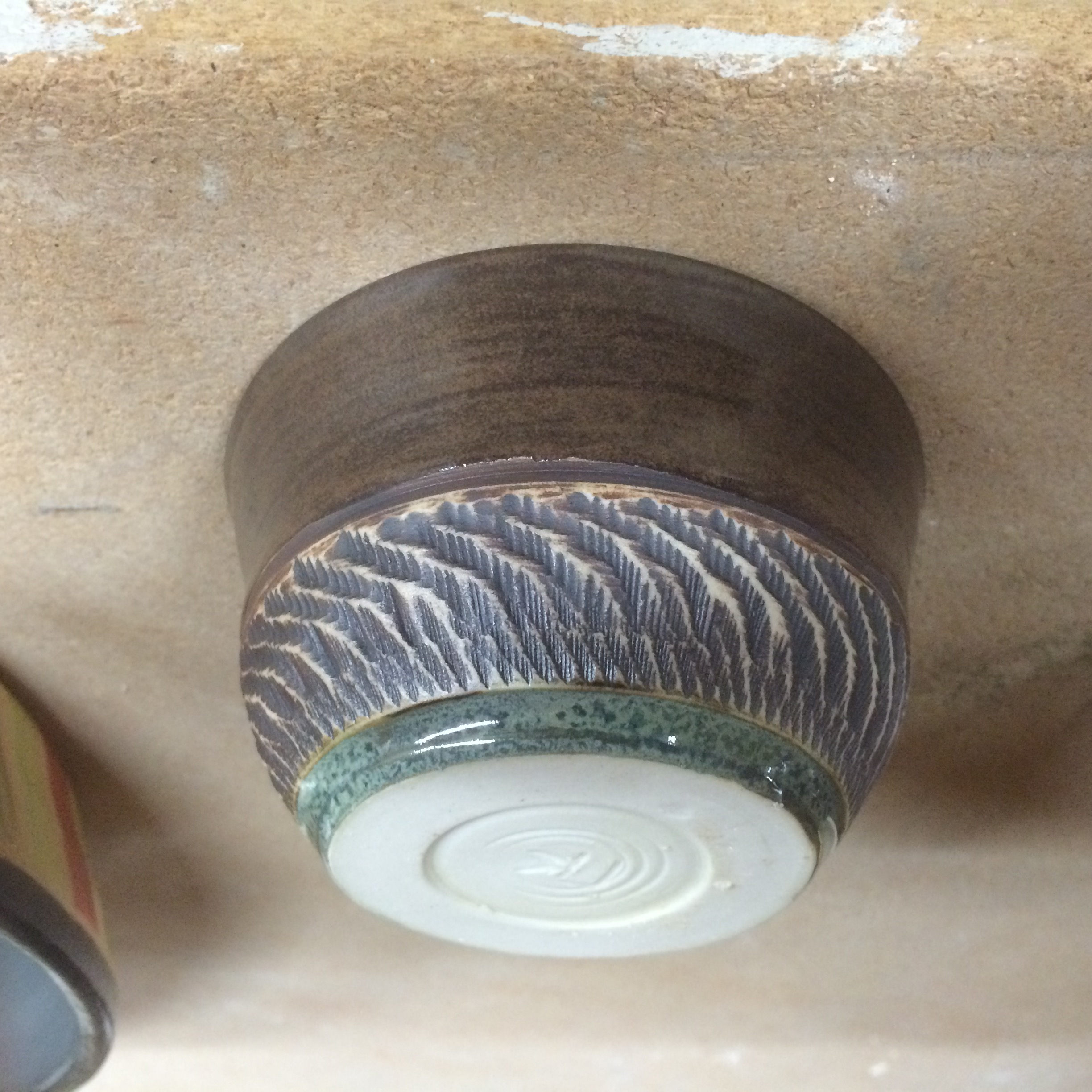 Textured tea bowl (inverted, emphasizing exterior texture), charcoal shino glaze, iron oxide, copper band highlight