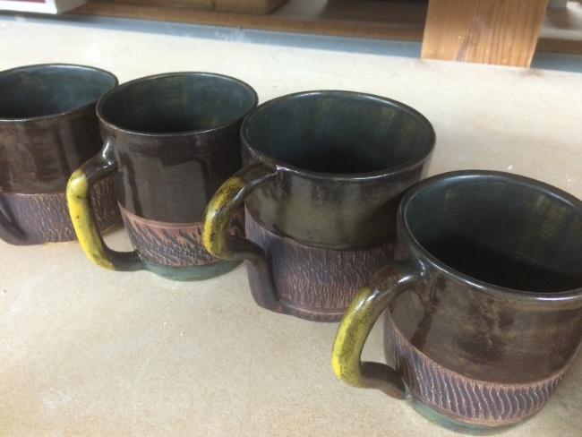 Textured ceramic mugs with iron oxide and charcoal shino glaze Textured ceramic mugs with iron oxide and charcoal shino glaze