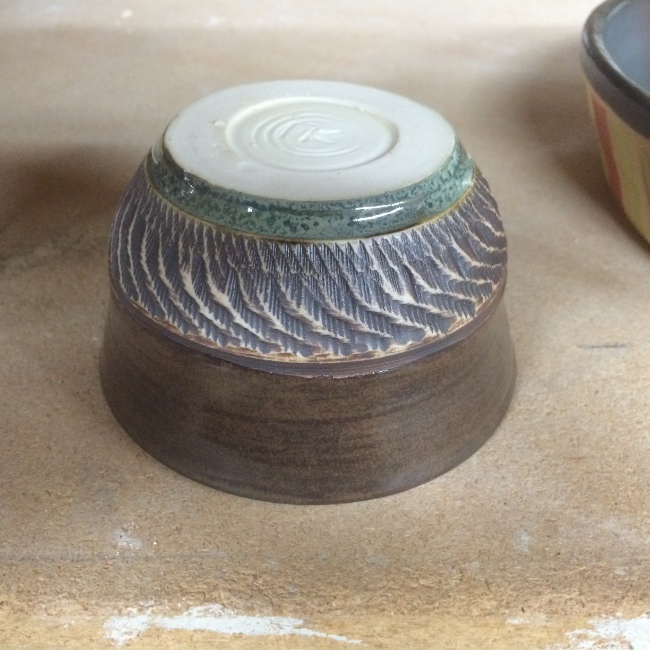 Textured tea bowl (inverted, emphasizing exterior texture), charcoal shino glaze, iron oxide, copper band highlight Textured tea bowl (inverted, emphasizing exterior texture), charcoal shino glaze, iron oxide, copper band highlight